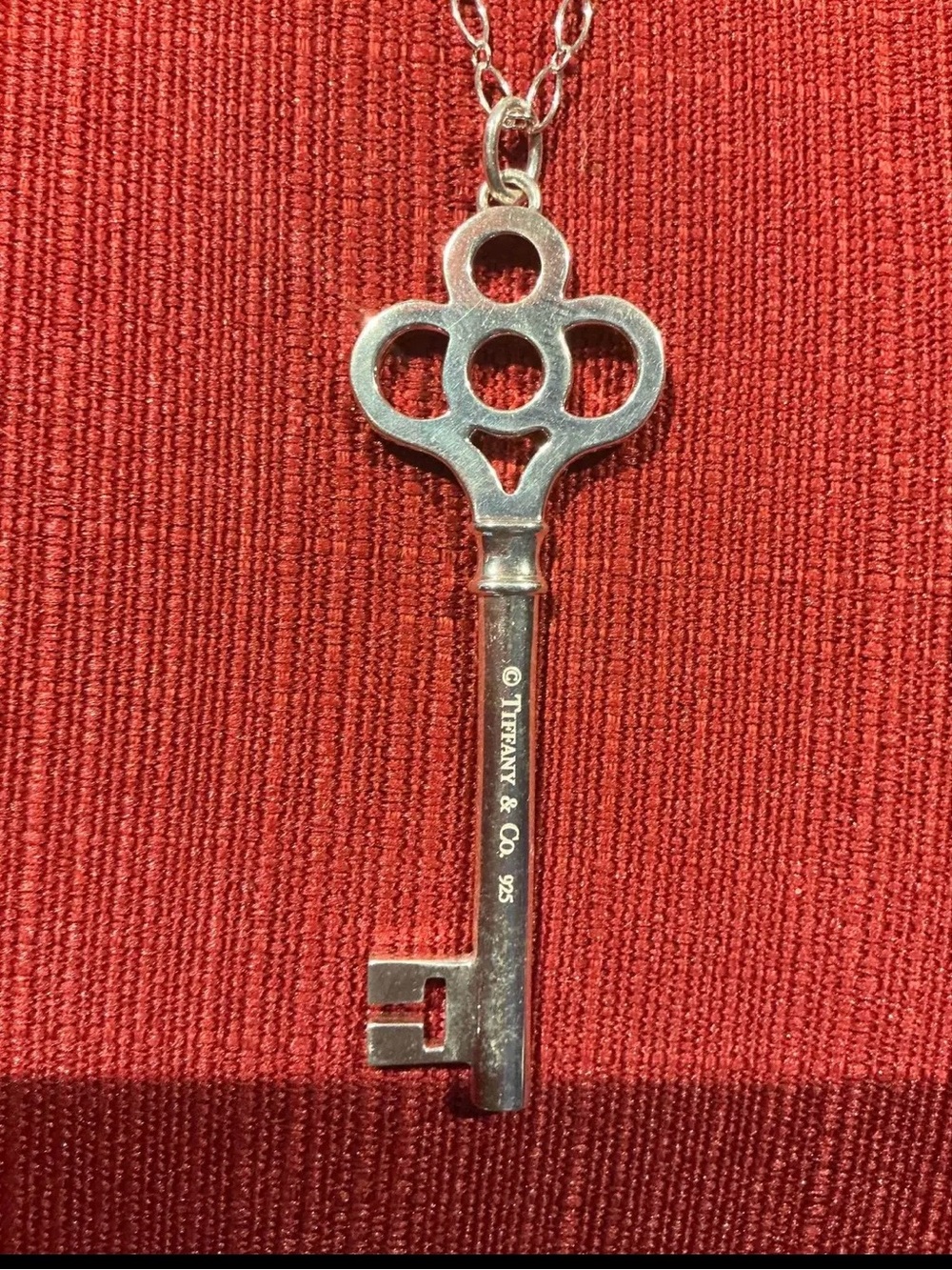Tiffany & Co. Silver Key Pendant on Chain - Red Background